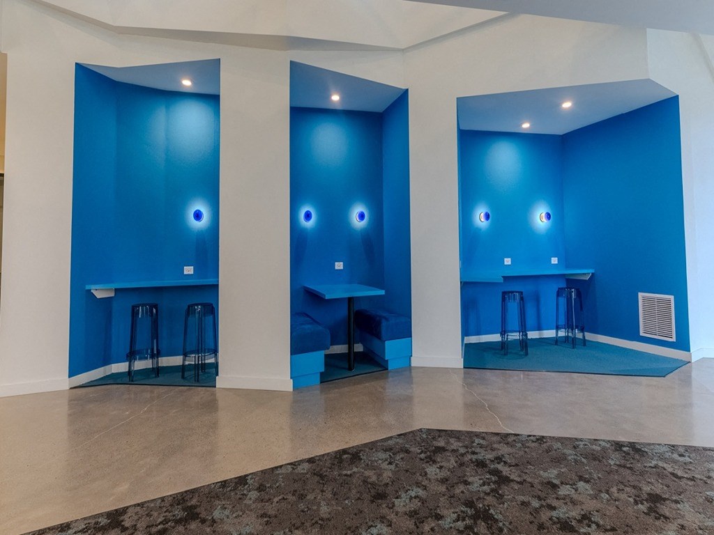 a room with blue walls and tables and stools